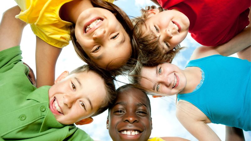 A group of diverse children playing outside. A group of diverse children playing outside.